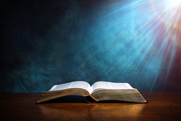 Open,Bible,On,A,Wood,Table,With,Light,Coming,From